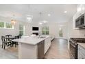 Bright, open kitchen with large island, stainless steel appliances, and modern lighting flowing into the living space at 210 Silas St, Durham, NC 27705
