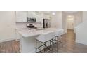 Modern kitchen boasts a large island with seating, stainless appliances, and stylish white cabinets at 210 Silas St, Durham, NC 27705