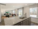 Open concept kitchen offers stainless steel appliances, a granite countertop, and connects to the living space at 214 Oak Barrel St, Smithfield, NC 27577