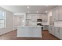Open kitchen featuring gray cabinets, stainless steel appliances, and a large center island at 2322 Sugar Cone Way, Fuquay Varina, NC 27526