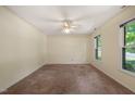 Spacious bedroom with neutral carpet, ceiling fan, and a large window for ample natural light at 2417 Lawrence Dr, Raleigh, NC 27603
