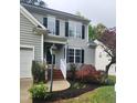Exterior view of home showcasing the entry way with brick steps, lush landscaping, and neutral colored siding at 2424 Horizon Hike Ct, Raleigh, NC 27603