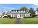 Charming two-story home with black shutters, landscaped yard, and inviting front entrance at 305 N Ellis Ave, Dunn, NC 28334