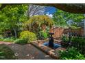 Backyard features a brick patio, water feature, lush plants, and brick walls creating a serene outdoor space at 315 Oakwood Ave, Raleigh, NC 27601