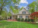 Charming home with manicured lawn, mature trees, and inviting front porch showcasing classic architectural details at 341 Heather Bluffs Dr, Garner, NC 27529