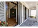 Inviting covered porch with gray stone flooring and view to bright green accent wall at 3513 Bellevue Rd, Raleigh, NC 27609