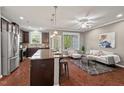 Open-concept kitchen flowing into a living area, with an island and stainless steel appliances at 36 Argonaut Dr, Durham, NC 27705