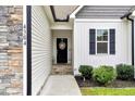 Up-close view of the front door shows stone accents and a welcoming wreath at 4304 S Greg Allen Way, Oxford, NC 27565