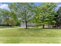 Beautiful two-story home with attached garage and a lush green lawn surrounded by mature trees at 5424 Westminster Ln, Fuquay Varina, NC 27526