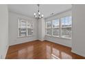 Bright dining room featuring hardwood floors, a modern chandelier, and an abundance of natural light at 5702 Cameo Glass Way, Raleigh, NC 27612