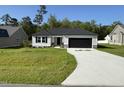 Charming single-story home with a dark gray roof, garage, and a driveway at 58 Heatherglenn Cir, Princeton, NC 27569