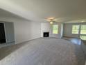 Spacious living room with a fireplace, fan, and large windows at 58 Heatherglenn Cir, Princeton, NC 27569