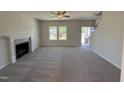Bright living room features a cozy fireplace, neutral carpet, and natural light from the windows at 61 Heatherglenn Cir, Princeton, NC 27569