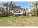 A well-maintained home sits amongst mature trees and manicured shrubs on a vast green lawn at 6702 Huntsboro Rd, Oxford, NC 27565