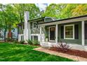 Inviting entryway featuring a classic black door, manicured bushes, and a well-maintained lawn at 7409 Fiesta Way, Raleigh, NC 27615