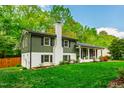A beautifully landscaped home showcases its lush green lawn, fresh siding, and a white brick chimney at 7409 Fiesta Way, Raleigh, NC 27615