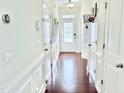 Bright hallway with hardwood floors, white trim and walls, and a mini basketball hoop on a door at 743 Silver Stream Ln, Cary, NC 27519