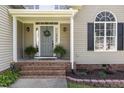 Inviting front porch featuring brick steps, decorative plants, and stylish front door with sidelights at 756 Rockville Rd, Wake Forest, NC 27587