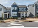 Charming blue two-story home featuring a covered front porch and well-manicured landscaping at 781 Cormiche Ln, Wake Forest, NC 27587