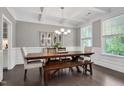 Elegant dining room with coffered ceilings, hardwood floors, a large table, and ample natural light at 8016 Parker Mill Trl, Fuquay Varina, NC 27526