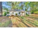 Charming one-story home with a covered front porch and mature trees in a tranquil setting at 8175 Nc 27 E, Coats, NC 27521