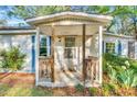 Inviting front porch with wooden railings and a cozy entryway for relaxing and enjoying the outdoors at 8175 Nc 27 E, Coats, NC 27521
