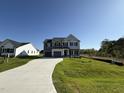 Spacious two-story home with a three car garage and a long driveway on a large lot under a cloudless blue sky at 87 Heatherglenn Cir, Princeton, NC 27569