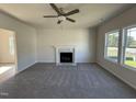 Inviting living room with fireplace, neutral color palette, plush carpeting, and abundant natural light from large windows at 87 Heatherglenn Cir, Princeton, NC 27569