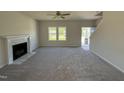 Bright and airy living room featuring neutral walls, plush carpeting, a fireplace, and natural light from the windows at 87 Heatherglenn Cir, Princeton, NC 27569