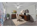 Well-lit home office with dark wood desk, comfortable chair, and decorative shelving at 8812 Forester Ln, Apex, NC 27539
