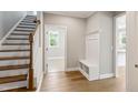 Entryway featuring a coat rack with storage bench, wood floors and staircase to the left at 9220 Yardley Town Dr, Wake Forest, NC 27587