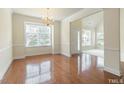 Elegant living room showcasing gleaming hardwood floors, and abundant natural light from large windows at 9531 Vira Dr, Raleigh, NC 27617