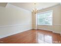 Bright, spacious living room featuring hardwood floors, a chandelier, and large window views at 9531 Vira Dr, Raleigh, NC 27617