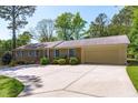Spacious ranch home featuring an attached garage and long driveway surrounded by greenery at 1005 Greenwood Cir, Cary, NC 27511