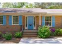 Welcoming front entrance with a bright blue door, brick steps, and manicured landscaping at 1005 Greenwood Cir, Cary, NC 27511