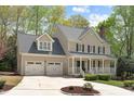 Charming two-story home featuring a covered front porch, well-manicured landscaping, and a two-car garage at 102 Parkbranch Ln, Cary, NC 27519