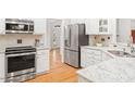 Modern kitchen showcasing stainless steel appliances, white cabinets, and stone countertops at 103 Caymus Ct, Cary, NC 27519