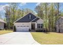 Charming single Gathering home with a two car garage, manicured lawn and front yard at 103 Sunlight Cv, Louisburg, NC 27549