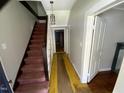 Hallway featuring a wooden staircase and visible wood floor, with a light fixture adding a touch of warmth at 104 N 16Th St, Erwin, NC 28339