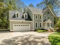 Two-story home with two-car garage, covered front porch, manicured lawn, and mature trees at 105 Toynbee Pl, Chapel Hill, NC 27514