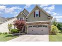 Two story home with green siding, stone accents, a two-car garage and beautifully landscaped front yard at 1109 Forest Willow Ln, Morrisville, NC 27560