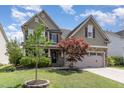 Two story home with green siding, stone accents, a two-car garage and beautifully landscaped front yard at 1109 Forest Willow Ln, Morrisville, NC 27560