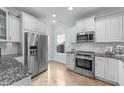 Kitchen featuring stainless steel appliances, white cabinetry, and granite countertops at 1126 Russet Ln, Apex, NC 27523