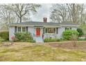 Exterior shot of the home with a red door, showing the front yard, landscape and brick exterior at 116 Crawford Rd, Hillsborough, NC 27278