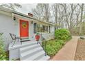 Charming exterior of a single-story home with a bright red door, brick walkway and fresh landscaping at 116 Crawford Rd, Hillsborough, NC 27278