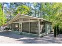 Attractive green home with a screened porch, gravel landscaping, and lush surroundings at 142 Blackhawk Dr, Louisburg, NC 27549