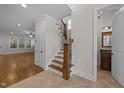 Bright entryway with hardwood floors, staircase, and view of the living room and half bathroom at 1512 Piazzo Ct, Apex, NC 27502