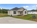 Charming one-story home with neutral siding, black front door, and a concrete driveway at 170 Brookhaven Dr, Spring Hope, NC 27882