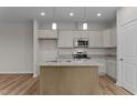 Modern kitchen with grey cabinets, granite countertops, stainless appliances, and a center island at 170 Brookhaven Dr, Spring Hope, NC 27882