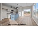 Bright kitchen featuring white cabinets, a blue island, stainless steel appliances, and a sliding door to the deck at 170 Brookhaven Dr, Spring Hope, NC 27882